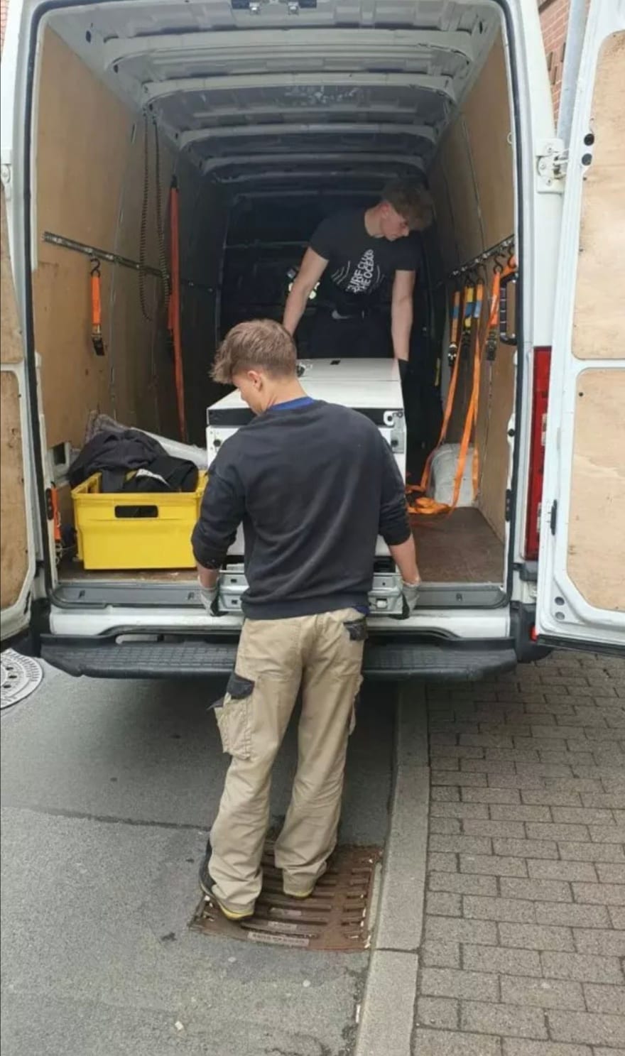 Helfer beim Beladen am Heck eines Fahrzeugs